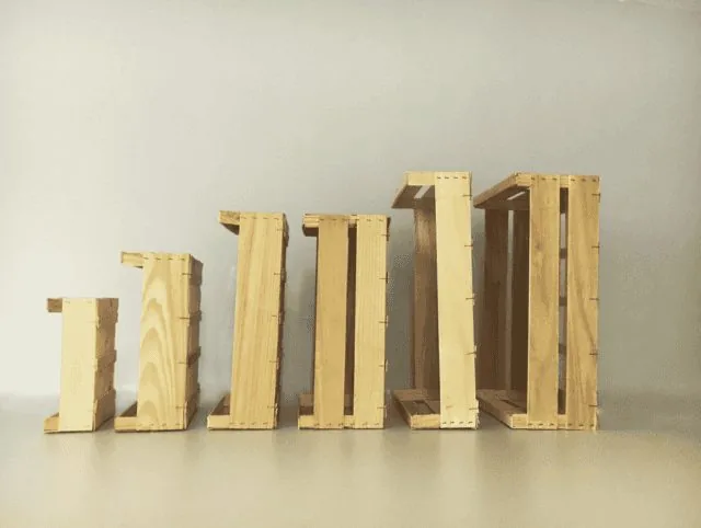 Six hauteurs de cagettes en bois alignées, de la plus basse à la plus haute